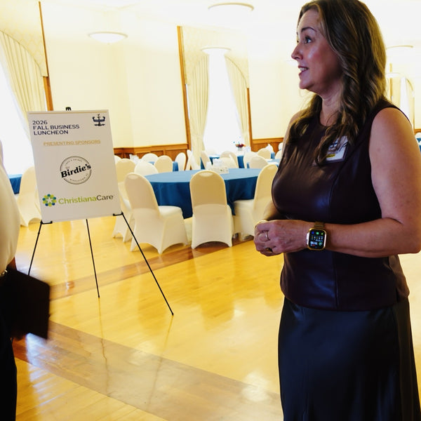 Dr. Niki Serravalle beside the presenting sponsors sign at Middletown Memorial Hall