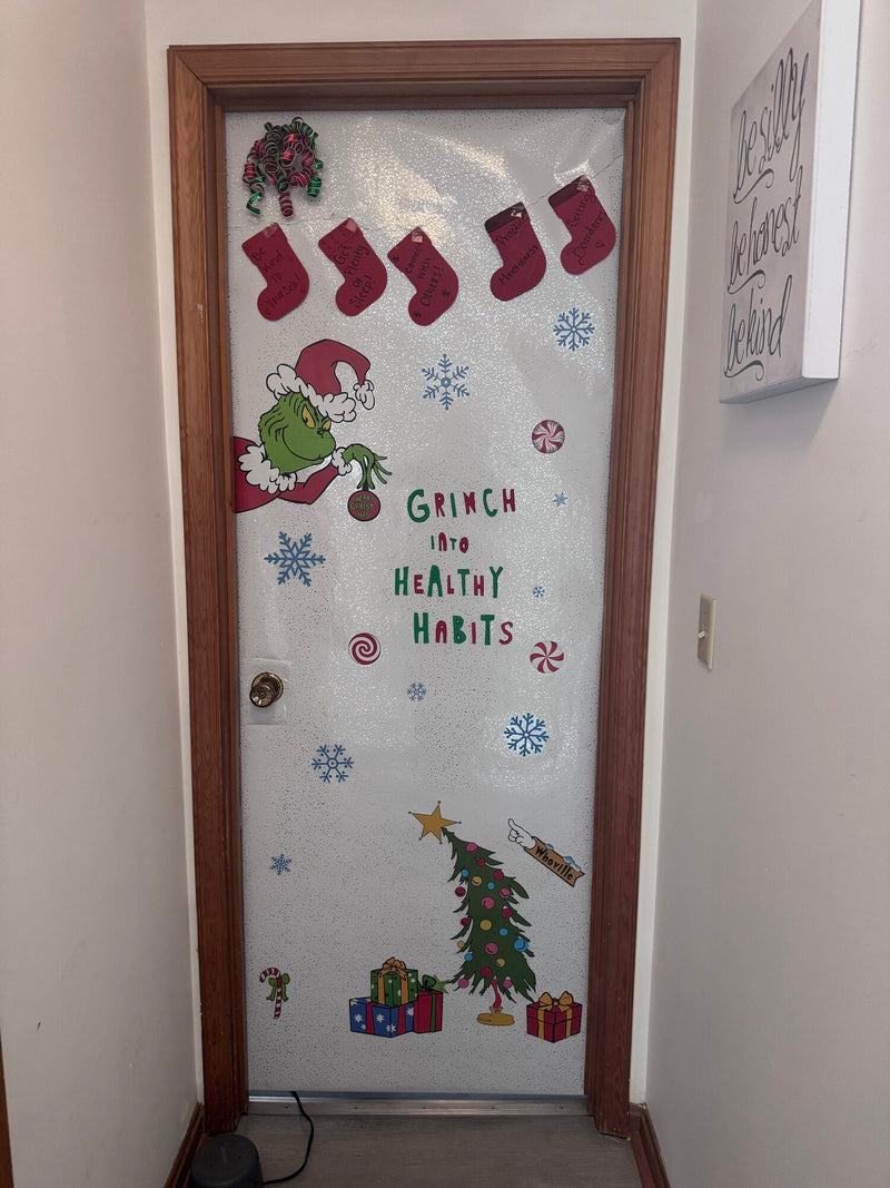 Office door decorated Grinch Into Healthy Habits, with stockings reading be kind to yourself, get plenty of sleep, connect with others, practice mindfulness and setting boundaries