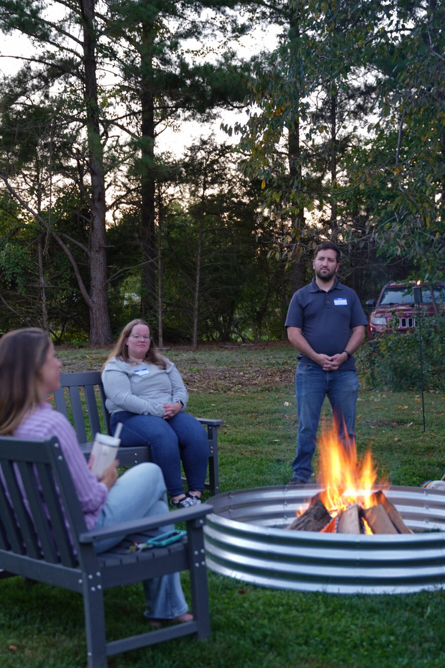 Providers in conversation on benches around the fire