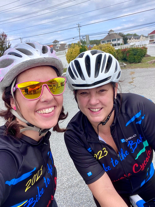 Niki and a fellow rider in helmets and Bike to the Bay jerseys