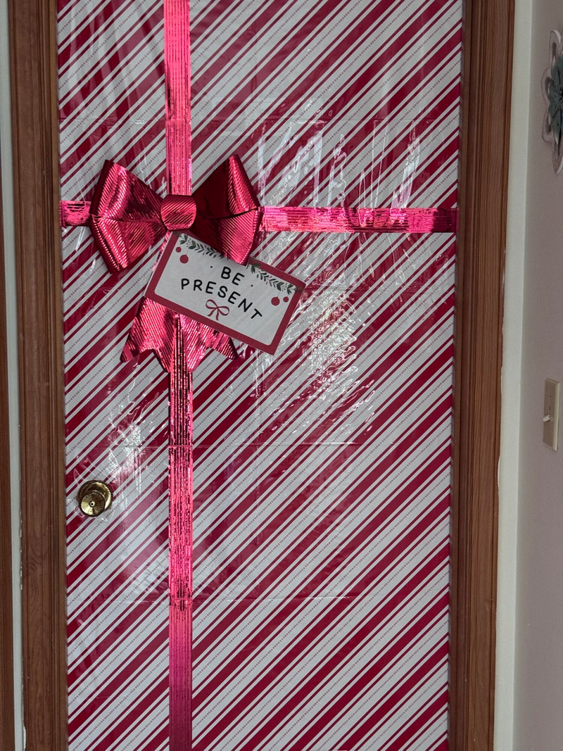Office door wrapped like a present in candy-cane paper with a tag reading Be Present