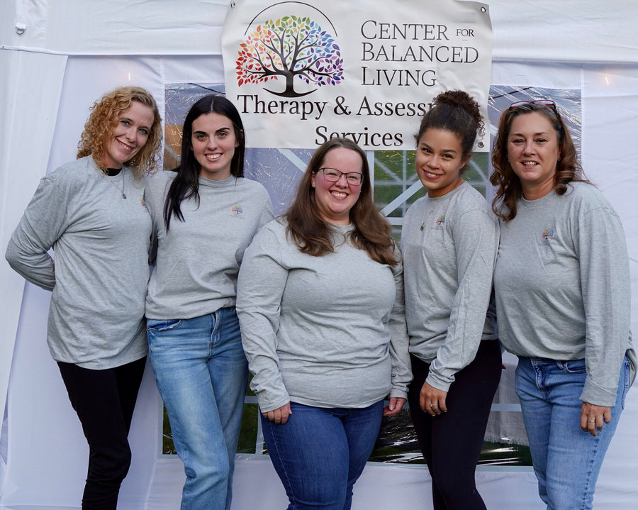 The Center for Balanced Living team in gray shirts under the practice banner